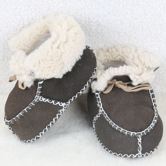 Pair of brown sheepskin baby booties with fluffy cream cuffs