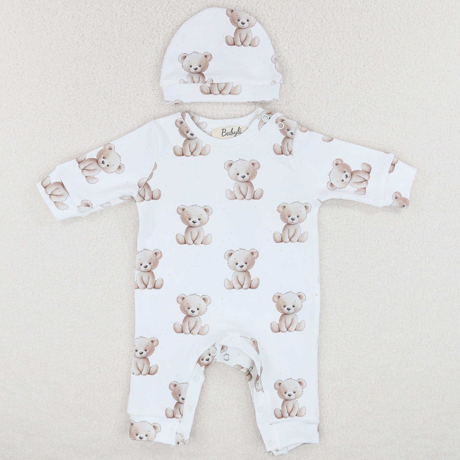 Newborn baby wearing white teddy bear cotton romper and hat