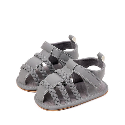 Baby unisex grey sandals pair from low front angle showing triple braided cross strap and velcro closure by Babyli, soft sole baby shoes UK