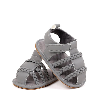 Baby unisex grey sandals pair showing triple braided strap detail and rubber sole from diagonal angle by Babyli, soft sole baby shoes UK