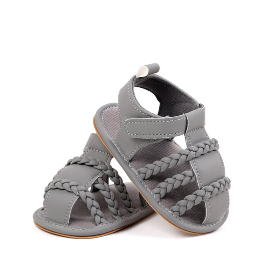 Baby unisex grey sandals pair showing triple braided strap detail and rubber sole from diagonal angle by Babyli, soft sole baby shoes UK