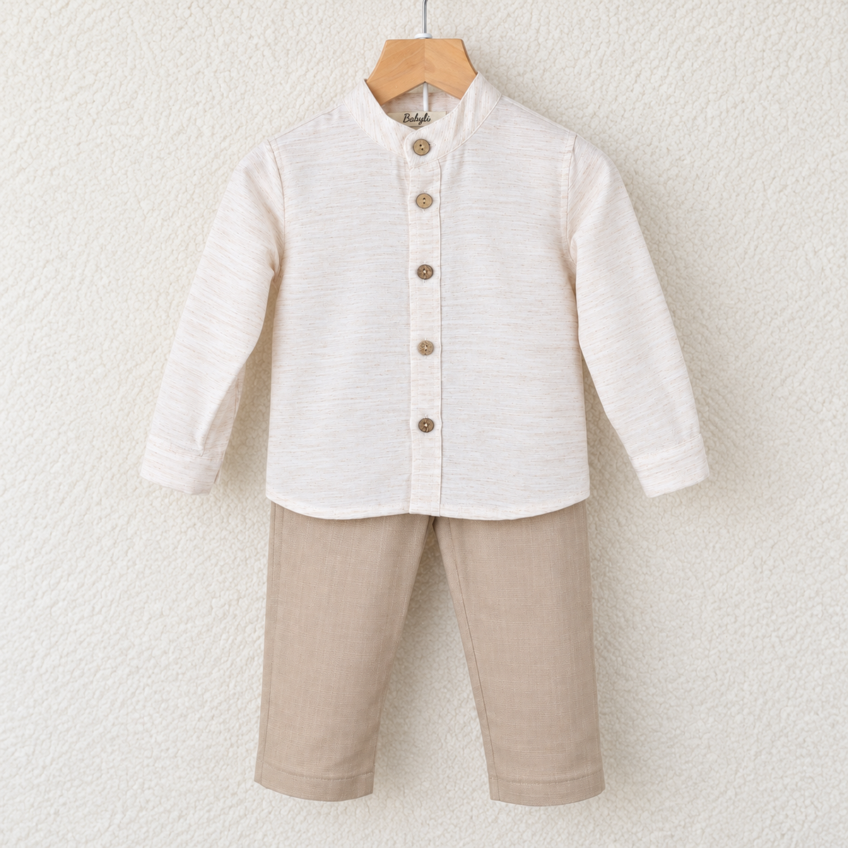 Babyli cream shirt and beige trousers set for babies and toddlers on a wooden hanger