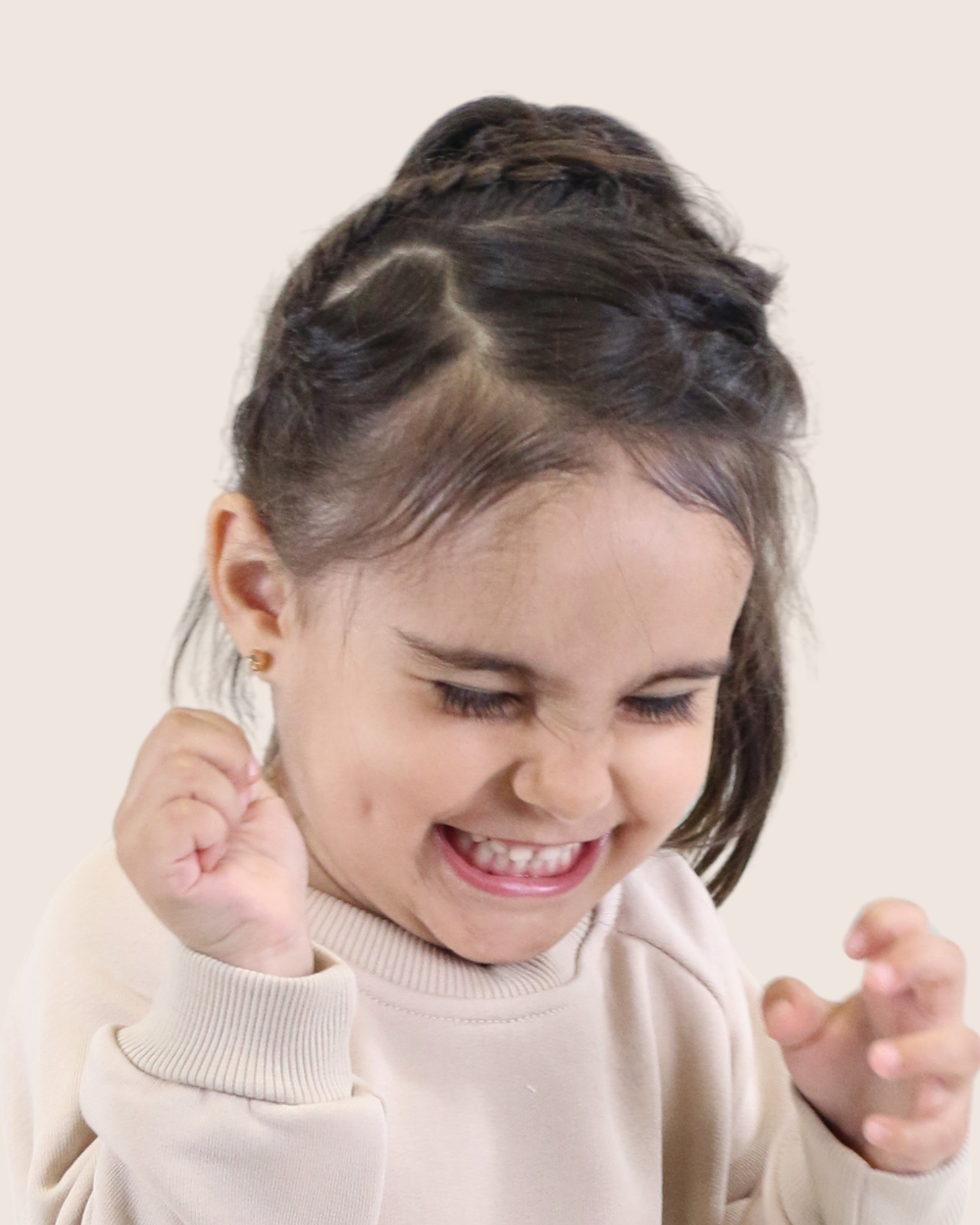 Happy smiling girl wearing a cream turtleneck sweater by Babyli, boutique baby and toddler clothing UK