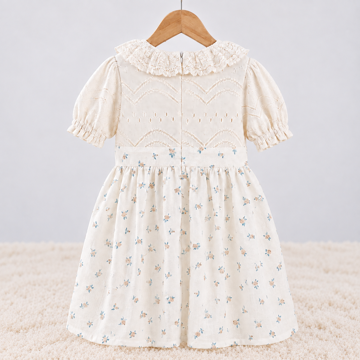Back view of Babyli ivory floral baby and toddler knit dress with ruffle collar, puff sleeves and gathered floral skirt