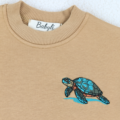Embroidered sea turtle detail on Babyli mustard baby tracksuit