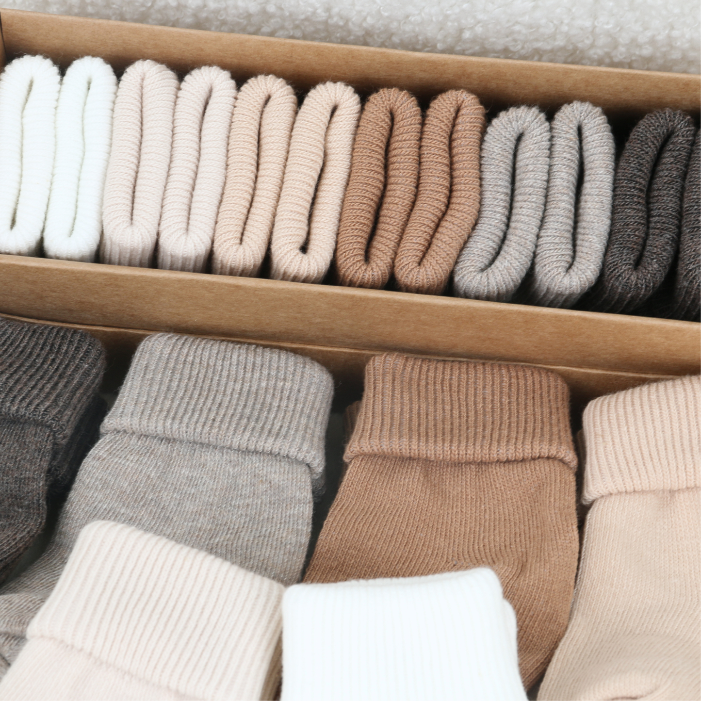 Newborn baby socks in taupe, grey and neutral tones stored in a drawer