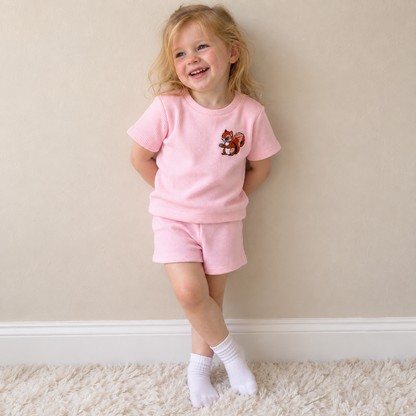 Toddler wearing Babyli pink squirrel embroidered t-shirt and shorts set, candid photo