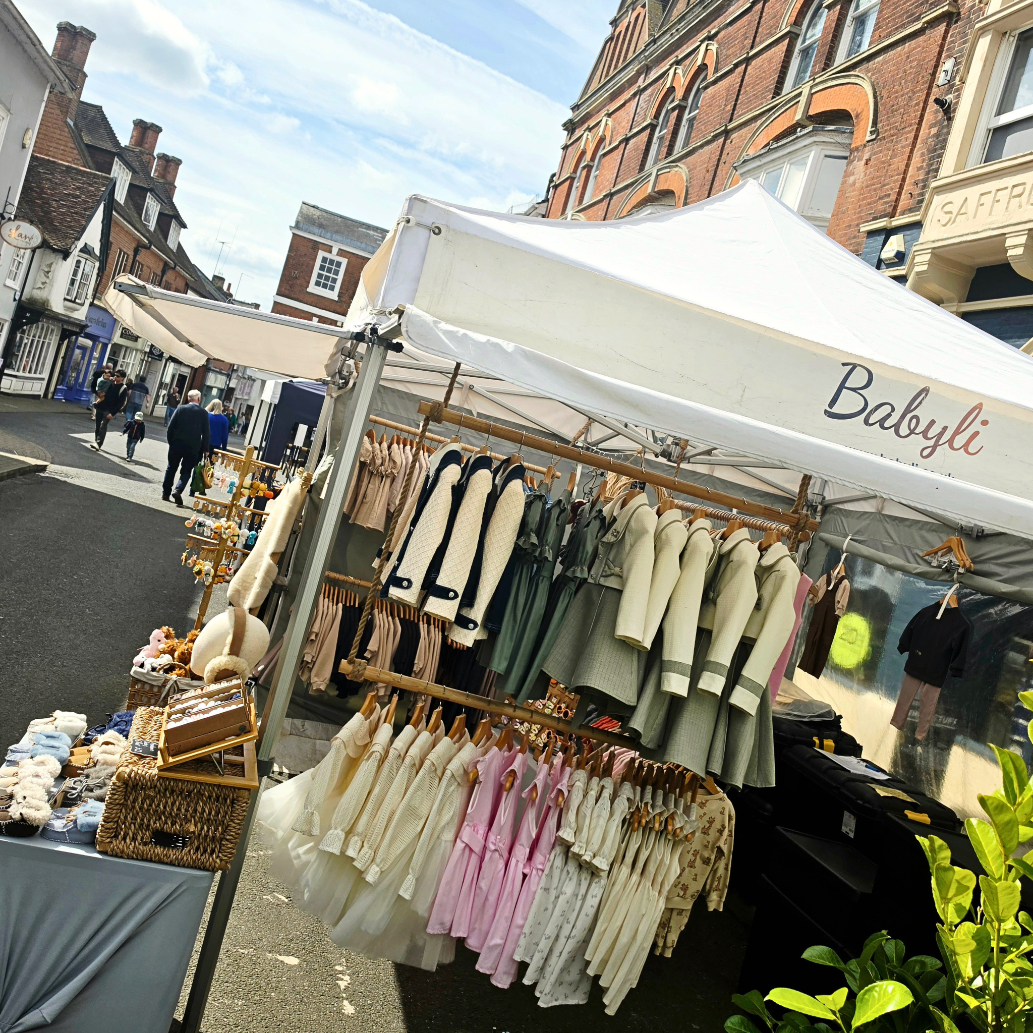 Babyli boutique baby and toddler clothing stall at Saffron Walden market, UK, displaying seasonal collections and accessories