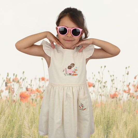 Girls sleeveless linen dress with rabbit embroidery and floral details.