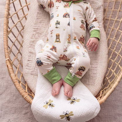 Close-up of Babyli Farmyard Zip Baby Sleepsuit showing farm animal print, tractor design and full-length zip fastening