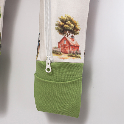 Close-up of Babyli Farmyard Double Zip Baby Sleepsuit showing two-way zip fastening, soft green ribbed cuff and farmyard print detail