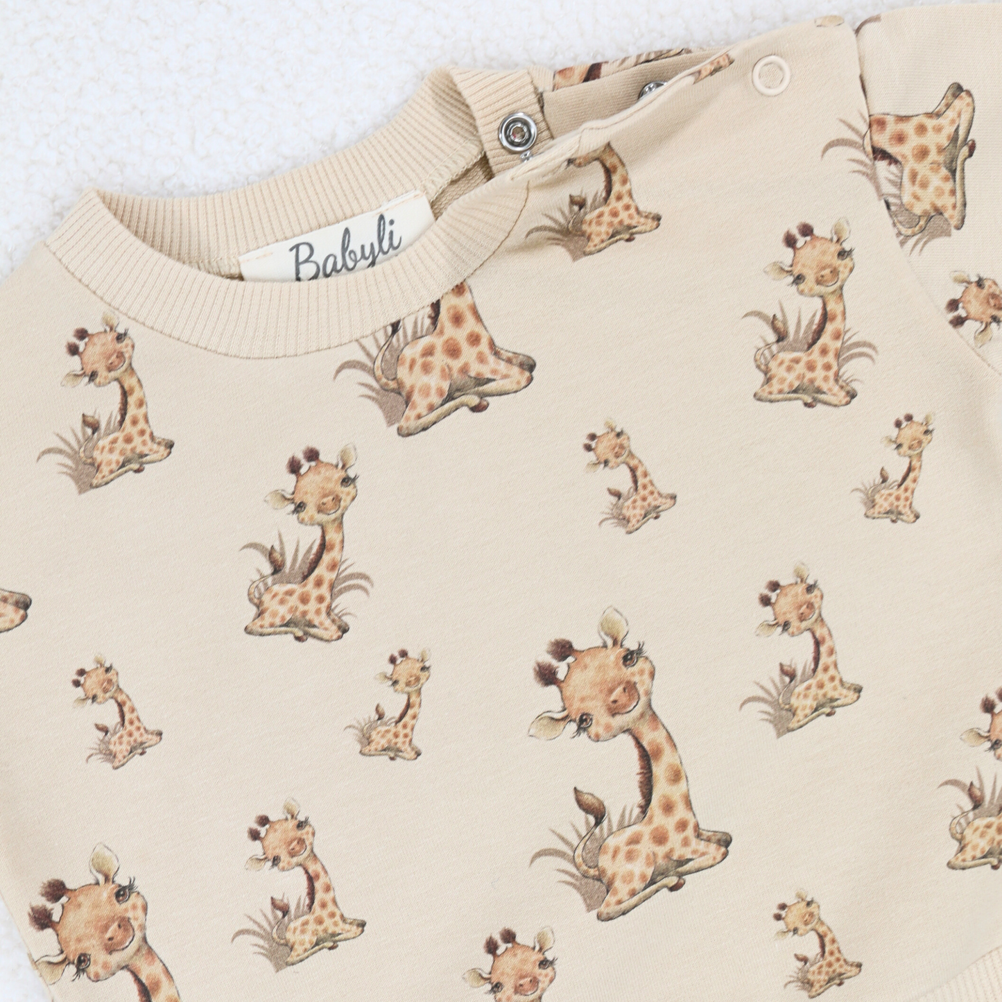 Close-up of beige baby and toddler sweatshirt with giraffe print