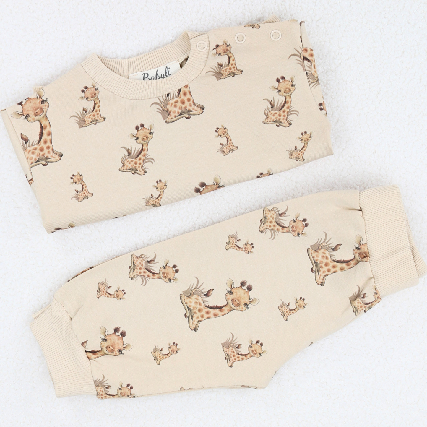 Folded beige baby and toddler  two-piece set with giraffe print