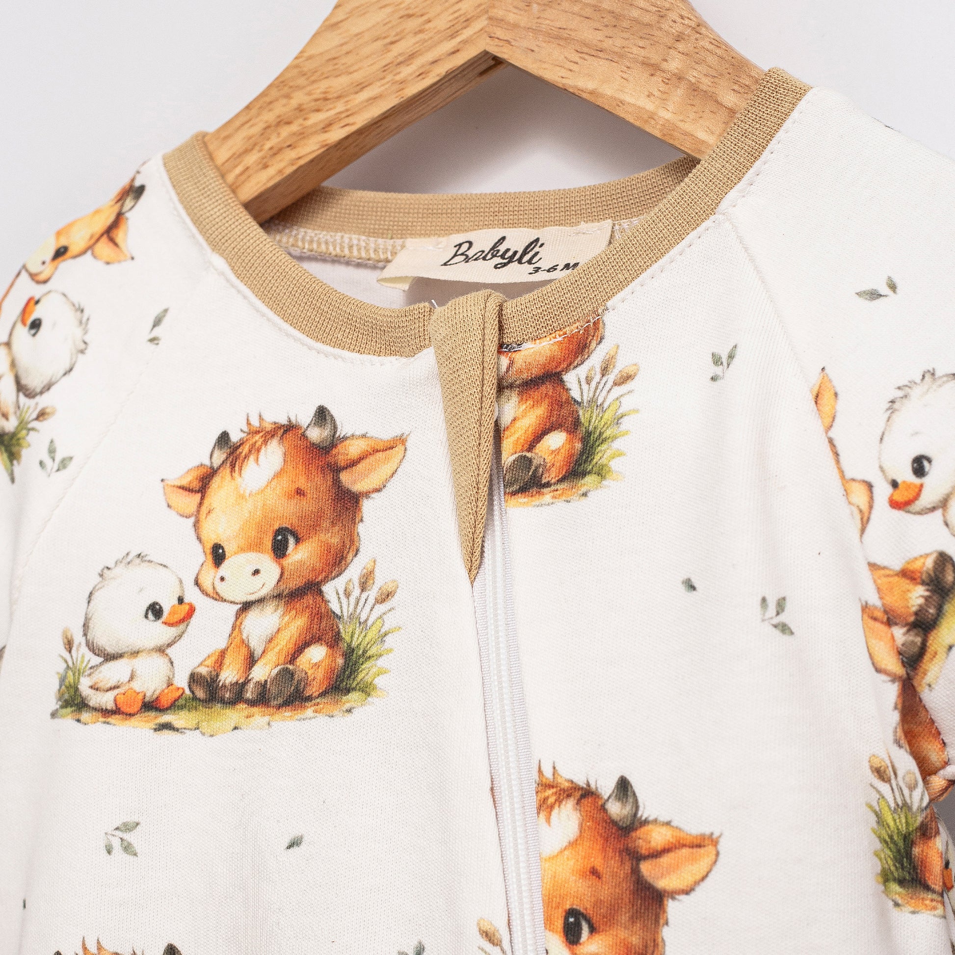 Close-up of Highland Cow Double Zip Baby Sleepsuit featuring two-way zip fastening and Highland cow print