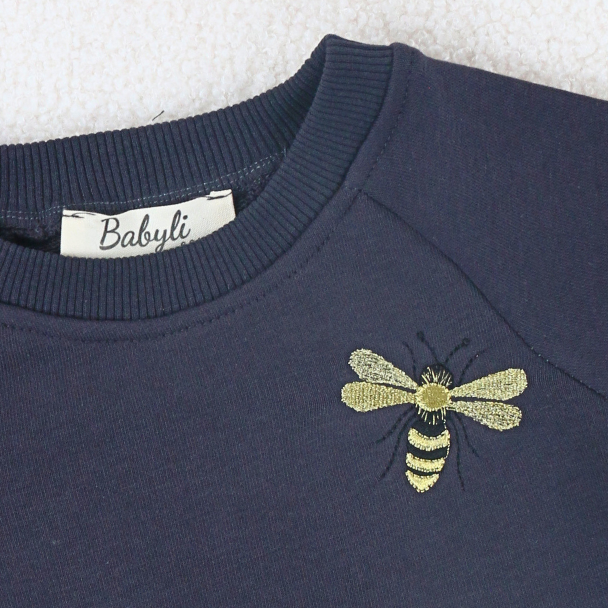 Young girl and boy wearing navy sweatshirt with bumblebee embroidery