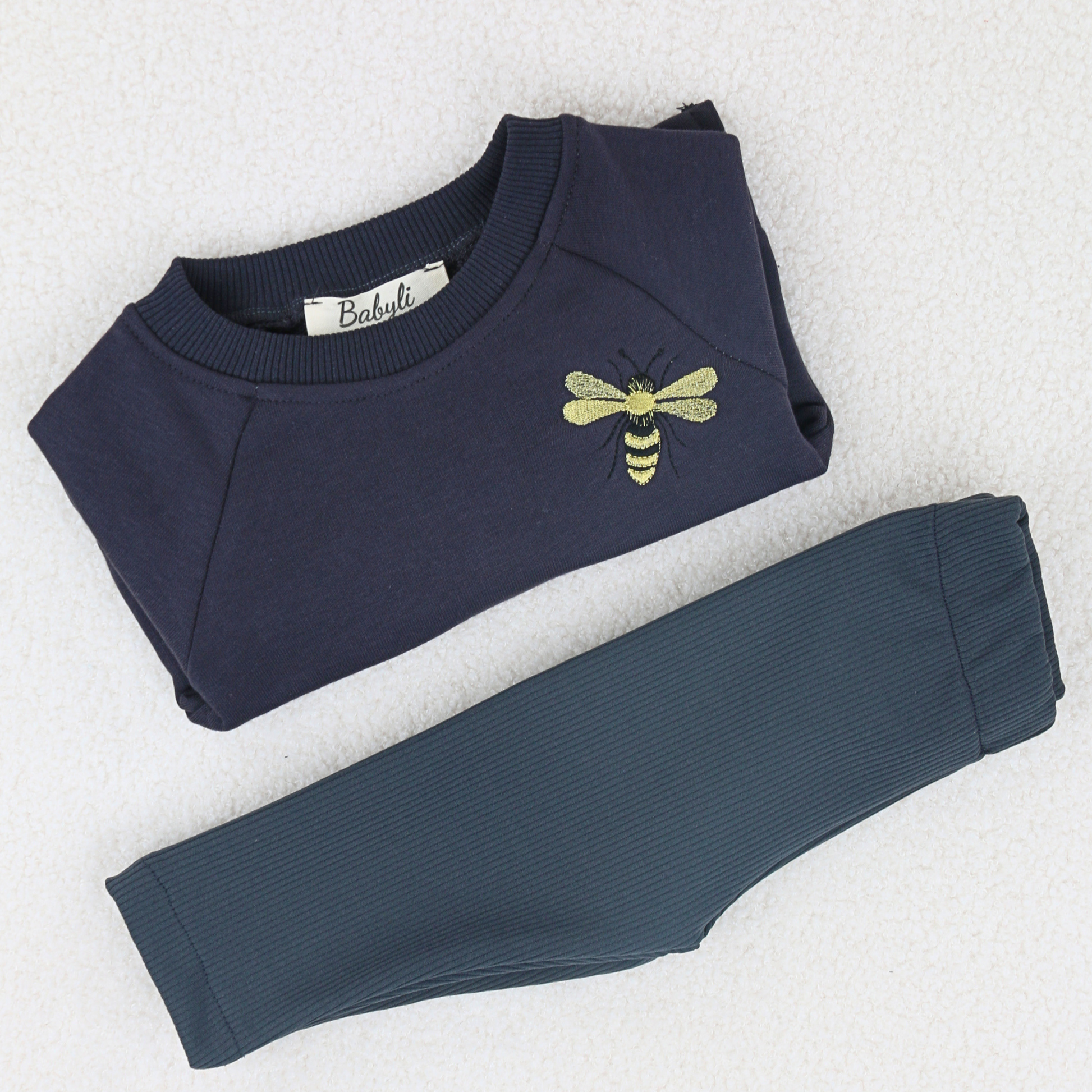 Young girl and boy wearing navy sweatshirt with bumblebee embroidery