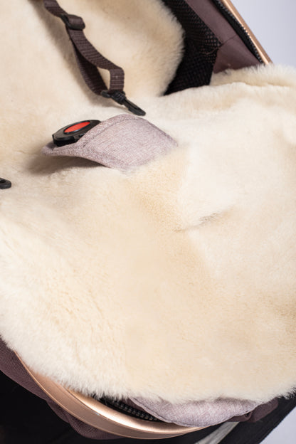 Cosy genuine sheepskin baby pram liner with soft wool finish.